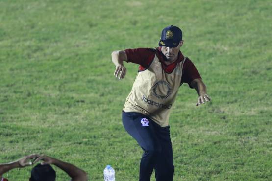 Pedro Troglio, entrenador del Olimpia, evitando el impacto de las botellas de agua que le lanzaron en el estadio Ceibeño.