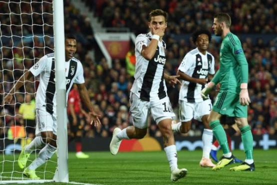 Juventus' Argentinian striker Paulo Dybala (C) celebrates after scoring the opening goal of the Champions League group H football match between Manchester United and Juventus at Old Trafford in Manchester, north west England, on October 23, 2018. (Photo by Oli SCARFF / AFP)