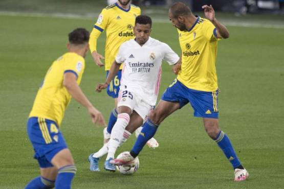 Real Madrid's Brazilian forward Rodrygo (C) challenges Cadiz' Spanish defender Rafael 'Fali' Gimenez (R) during the Spanish League football match between Cadiz and Real Madrid at the Ramon de Carranza stadium in Cadiz on April 21, 2021. (Photo by JORGE GUERRERO / AFP)