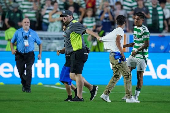 CHAPEL HILL, NORTH CAROLINA - JULY 23: A security guard escorts two young fans off the pitch and away from Luis Palma #7 of Celtic during the second half of their pre-season friendly match against Manchester City at Kenan Stadium on July 23, 2024 in Chapel Hill, North Carolina. Grant Halverson/Getty Images/AFP (Photo by GRANT HALVERSON / GETTY IMAGES NORTH AMERICA / Getty Images via AFP)
