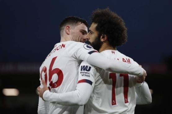 Liverpool's Egyptian midfielder Mohamed Salah (R) celebrates scoring their third goal with Liverpool's Scottish defender Andrew Robertson (L) during the English Premier League football match between Bournemouth and Liverpool at the Vitality Stadium in Bournemouth, southern England on December 7, 2019. (Photo by Adrian DENNIS / AFP) / RESTRICTED TO EDITORIAL USE. No use with unauthorized audio, video, data, fixture lists, club/league logos or 'live' services. Online in-match use limited to 120 images. An additional 40 images may be used in extra time. No video emulation. Social media in-match use limited to 120 images. An additional 40 images may be used in extra time. No use in betting publications, games or single club/league/player publications. /