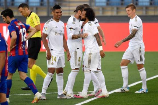Real Madrid's Brazilian defender Marcelo (2R) celebrates his goal with teammates during the Spanish League football match between Real Madrid CF and SD Eibar at the Alfredo di Stefano stadium in Valdebebas, on the outskirts of Madrid, on June 14, 2020. (Photo by PIERRE-PHILIPPE MARCOU / AFP)