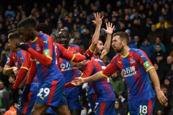 Crystal Palace's Serbian midfielder Luka Milivojevic (C) celebrates scoring their third goal from the penalty spot to extend their lead 1-3 during the English Premier League football match between Manchester City and Crystal Palace at the Etihad Stadium in Manchester, north west England, on December 22, 2018. (Photo by Oli SCARFF / AFP) / RESTRICTED TO EDITORIAL USE. No use with unauthorized audio, video, data, fixture lists, club/league logos or 'live' services. Online in-match use limited to 120 images. An additional 40 images may be used in extra time. No video emulation. Social media in-match use limited to 120 images. An additional 40 images may be used in extra time. No use in betting publications, games or single club/league/player publications. /