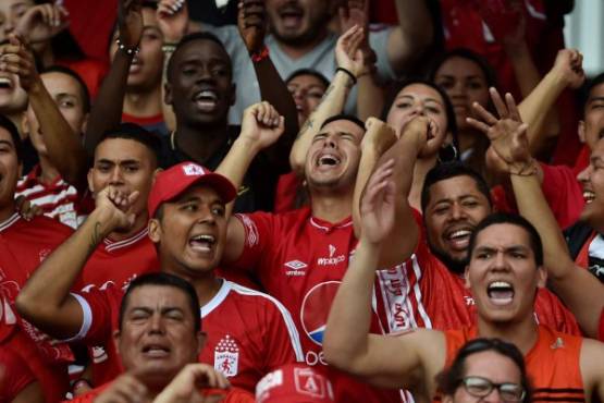 America de Cali's supporters celebrate a goal against Atletico Junior during the Colombian First Division Football Championship final match at the Olimpico Pascual Guerrero stadium in Cali, Colombia, on December 7, 2019. (Photo by LUIS ROBAYO / AFP)