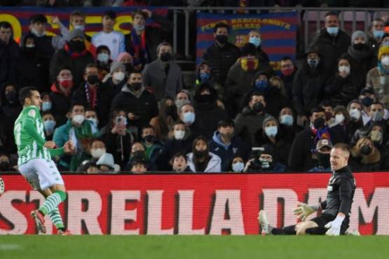 Real Betis' Spanish forward Juanmi (L) scores the opening goal during the Spanish League football match between FC Barcelona and Real Betis at the Camp Nou stadium in Barcelona on December 4, 2021. (Photo by LLUIS GENE / AFP)