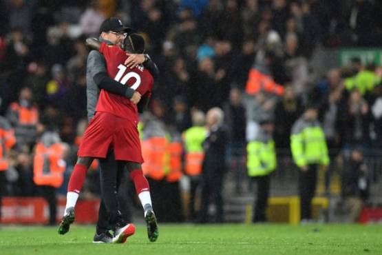 Liverpool's German manager Jurgen Klopp (L) embraces Liverpool's Senegalese striker Sadio Mane after winning the English Premier League football match between Liverpool and Tottenham Hotspur at Anfield in Liverpool, north west England on October 27, 2019. (Photo by Paul ELLIS / AFP) / RESTRICTED TO EDITORIAL USE. No use with unauthorized audio, video, data, fixture lists, club/league logos or 'live' services. Online in-match use limited to 120 images. An additional 40 images may be used in extra time. No video emulation. Social media in-match use limited to 120 images. An additional 40 images may be used in extra time. No use in betting publications, games or single club/league/player publications. /