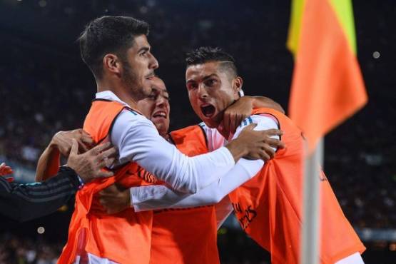 Real Madrid's forward Marco Asensio (L), Real Madrid's forward Lucas Vazquez and Real Madrid's Portuguese forward Cristiano Ronaldo (R) celebrate Barcelona's own goal during the first leg of the Spanish Supercup football match between FC Barcelona and Real Madrid CF at the Camp Nou stadium in Barcelona on August 13, 2017. / AFP PHOTO / Josep LAGO