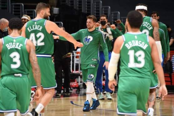 LOS ANGELES, CA - DECEMBER 27: Luka Doncic #77 of the Dallas Mavericks hi-fives his teammates during the game against the LA Clippers on December 27, 2020 at STAPLES Center in Los Angeles, California. NOTE TO USER: User expressly acknowledges and agrees that, by downloading and/or using this Photograph, user is consenting to the terms and conditions of the Getty Images License Agreement. Mandatory Copyright Notice: Copyright 2020 NBAE Andrew D. Bernstein/NBAE via Getty Images/AFP