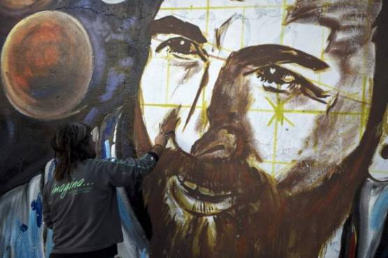 Artist Lisandro Urteaga paints a mural of Barcelona's football star Lionel Messi at the footballer's birthplace in Rosario, Santa Fe province, Argentina on June 29, 2017. Football and showbiz stars started gathering in Rosario for Latin America's celebrity wedding bash of the decade when Barcelona superstar Lionel Messi marries his childhood sweetheart Antonella Roccuzzo on June 30. / AFP PHOTO / EITAN ABRAMOVICH