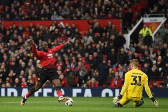 Manchester United's Belgian striker Romelu Lukaku (L) touches the ball past Reading's Finnish goalkeeper Anssi Jaakkola (R) to score their second goal during the English FA Cup third round football match between Manchester United and Reading at Old Trafford in Manchester, north west England, on January 5, 2019. (Photo by Oli SCARFF / AFP) / RESTRICTED TO EDITORIAL USE. No use with unauthorized audio, video, data, fixture lists, club/league logos or 'live' services. Online in-match use limited to 120 images. An additional 40 images may be used in extra time. No video emulation. Social media in-match use limited to 120 images. An additional 40 images may be used in extra time. No use in betting publications, games or single club/league/player publications. /
