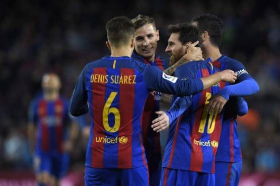 Barcelona's Argentinian forward Lionel Messi celebrates with teammates after scoring a goal during the Spanish league football match FC Barcelona vs CA Osasuna at the Camp Nou stadium in Barcelona on April 26, 2017. / AFP PHOTO / LLUIS GENE
