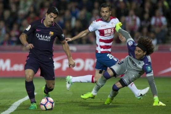 Granada's French defender Matthieu Saunier (C) and Mexican goalkeeper Guillermo Ochoa (R) vie with Barcelona's Uruguayan forward Luis Alberto Suarez during the Spanish league football match Granada FC vs FC Barcelona at Nuevo Los Carmenes stadium in Granada on April 2, 2017. / AFP PHOTO / JORGE GUERRERO