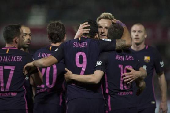Barcelona's Uruguayan forward Luis Suarez (C) celebrates a goal with teammates during the Spanish league football match Granada FC vs FC Barcelona at Nuevo Los Carmenes stadium in Granada on April 2, 2017. / AFP PHOTO / JORGE GUERRERO