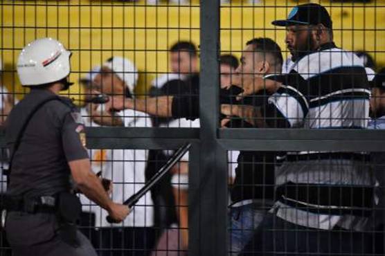 Fans of Brazil's Santos shout slogans at the riot police during the Copa Libertadores football match against Argentina's Independiente Pacaembu Stadium in Sao Paulo, Brazil, on August 28, 2018.The match was suspended in the 81st minute after fans of Santos threw bangers onto the field and the police was deployed to provide security. South America's governing body Conmebol awarded the first leg clash between the teams to Independiente with a 3-0 score just hours before today's match because Santos fielded and ineligible player. / AFP PHOTO / Nelson ALMEIDA