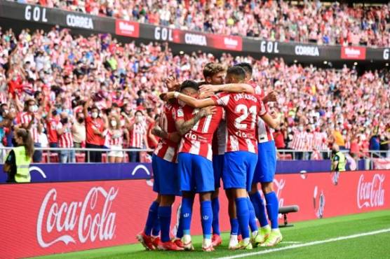 Atletico Madrid's Argentine forward Angel Correa (L) celebrates with teammates scoring the opening goal during the Spanish League football match between Club Atletico de Madrid and Elche CF at the Wanda Metropolitano stadium in Madrid on August 22, 2021. (Photo by JAVIER SORIANO / AFP)