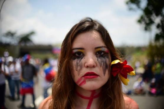 A Venezuelan opposition activist participates in a sit-in to block the Francisco Fajardo motorway in Caracas, on April 24, 2017.Protesters plan Monday to block Venezuela's main roads including the capital's biggest motorway, triggering fears of further violence after three weeks of unrest left 21 people dead. / AFP PHOTO / RONALDO SCHEMIDT