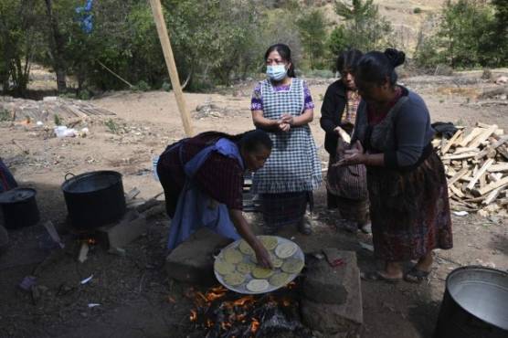 Women prepare food during the wake of Marvin Tomas, a Guatemalan migrant who was found murdered alongside other 18 people in the northern Mexican state of Tamaulipas last month, at Las Flores village in Comitancillo, Guatemala, on March 13, 2021. - On January 22, 19 charred bodies were found in Tamaulipas, a state on the border with the United States that has been rocked for years by organized crime gangs. Sixteen of the dead were determined to be Guatemalan and the other three of Mexican origin. (Photo by Johan ORDONEZ / AFP)