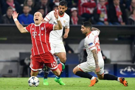 Bayern Munich's Dutch midfielder Arjen Robben is fouled by Sevilla's Argentinian midfielder Ever Banega (R) during the UEFA Champions League quarter-final second leg football match between FC Bayern Munich and Sevilla FC on April 11, 2018 in Munich, southern Germany. / AFP PHOTO / John MACDOUGALL