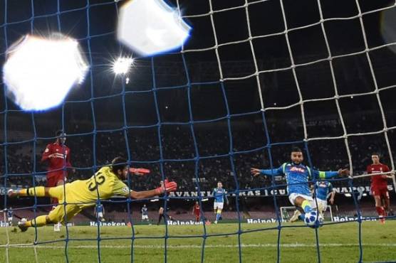 Napoli's Italian forward Lorenzo Insigne (R) scores a last minute goal against Liverpool's Brazilian goalkeeper Alisson (L) during the UEFA Champions League group C football match between Napoli and Liverpool on October 3, 2018 at the San Paolo stadium in Naples. / AFP PHOTO / Filippo MONTEFORTE