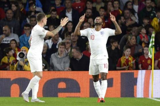 England's forward Raheem Sterling (R) celebrates after scoring a goal during the UEFA Nations League football match between Spain and England on October 15, 2018 at the Benito Villamarin stadium in Sevilla. (Photo by CRISTINA QUICLER / AFP)