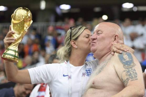 Two England fans hold a replica of the World Cup trophy before the Russia 2018 World Cup round of 16 football match between Colombia and England at the Spartak Stadium in Moscow on July 3, 2018. / AFP PHOTO / Juan Mabromata / RESTRICTED TO EDITORIAL USE - NO MOBILE PUSH ALERTS/DOWNLOADS