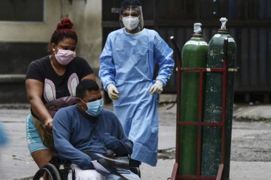 A patient with synptoms of COVID-19 coronavirus looks for assistance at the Hospital Escuela tents, in Tegucigalpa on June 29, 2020. - Honduras is overwhelmed by deaths caused by COVID-19 and the large number of people admitted to hospitals every day across the country. (Photo by ORLANDO SIERRA / AFP)