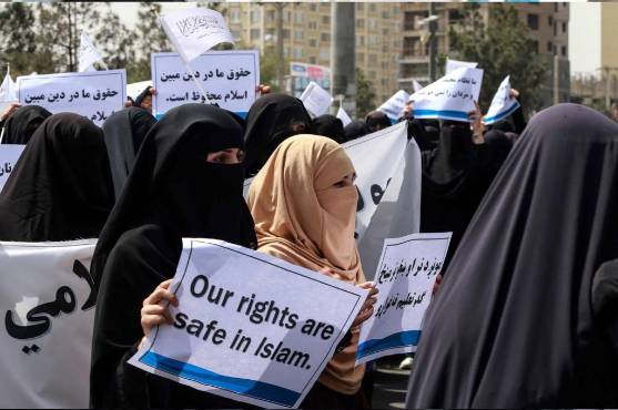 Centenares de mujeres afganas cubiertas con velo negro apoyan al régimen talibán.