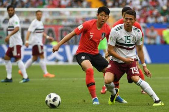 Héctor Moreno y el delantero Son Heung-min pelean el balón.