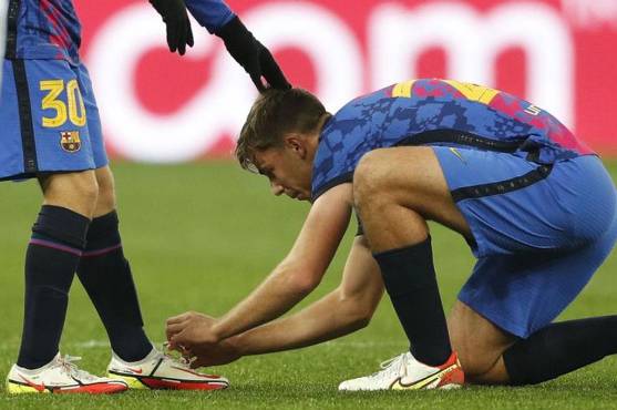 Nico le amarra los cordones de los botines a su compañero Gavi.