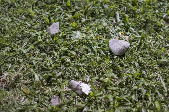 El estadio Morazán se convirtió en un campo de guerra tras el conflicto entre barras. Así quedó el césped del inmueble, lleno de piedras, entro otros proyectiles.