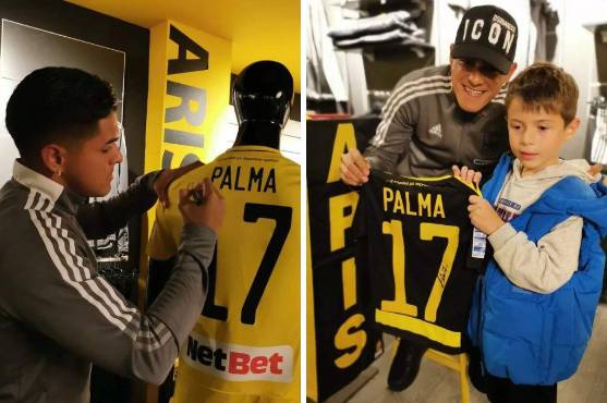 Luis Palma firmando sobre los productos oficiales de ARIS F.C. Tienda y tomándose fotos con pequeños admiradores.