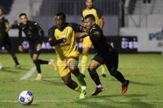 El delantero del Motagua, Iván 'Chino' López en plena disputa de la pelota con Darixon Vuelto del Real España. Fotos Alex Pérez y David Romero