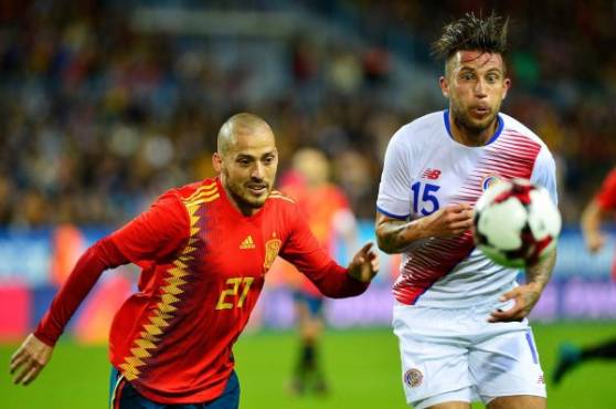 Spain's midfielder David Silva (L) fights for the ball with the ball with Costa Rica's midfielder David Guzman (R) during the international friendly football match Spain against Costa Rica at La Rosaleda stadium in Malaga on November 11, 2017. / AFP PHOTO / CRISTINA QUICLER