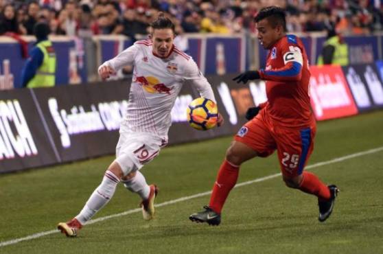 El centrocampista German Mejía presiona al jugador Alex Muyl del Red Bulls.