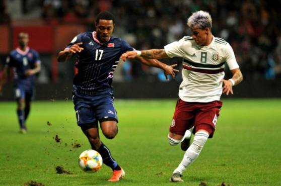 Mexico's Cristian Calderon (R) vies for the ball with Bermuda's Justin Donawa (L) during their Concacaf Nations League football match at Nemesio Diez stadium in Toluca, Mexico state, Mexico on November 19, 2019. (Photo by VICTOR CRUZ / AFP)
