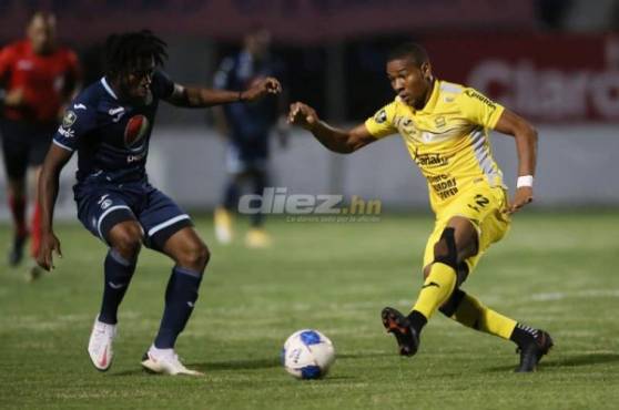 El delantero del Real España, Yeison Mejía, intenta quitarse la marca de Cristopher Meléndez del Motagua. Fotos | Emilio Flores