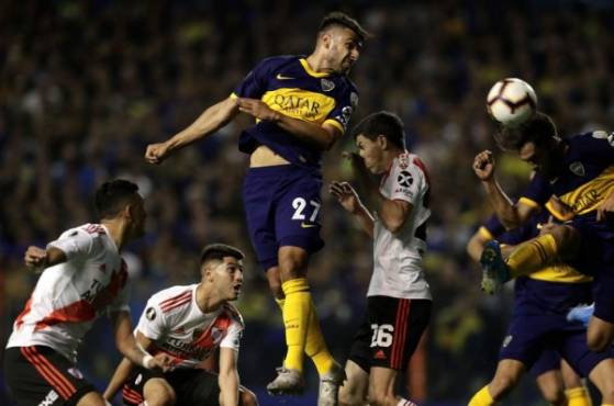 Boca Juniors' Eduardo Salvio heads the ball over River Plate's Kevin Sibille during their all-Argentine Copa Libertadores semi-final second leg football match at La Bombonera stadium in Buenos Aires, on October 22, 2019. (Photo by ALEJANDRO PAGNI / AFP)