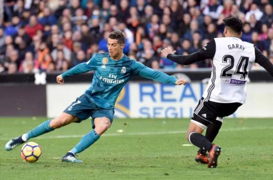 Real Madrid's Portuguese forward Cristiano Ronaldo (L) vies with Valencia's Argentinian defender Ezequiel Garay during the Spanish league football match between Valencia CF and Real Madrid CF at the Mestalla stadium in Valencia on January 27, 2018. / AFP PHOTO / JOSE JORDAN
