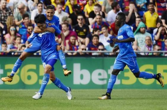 Getafe's midfielder from Japan Gaku Shibasaki (L bottom) celebrates a goal with teammates during the Spanish league football match Getafe CF vs FC Barcelona at the Col. Alfonso Perez stadium in Getafe on September 16, 2017. / AFP PHOTO / PIERRE-PHILIPPE MARCOU