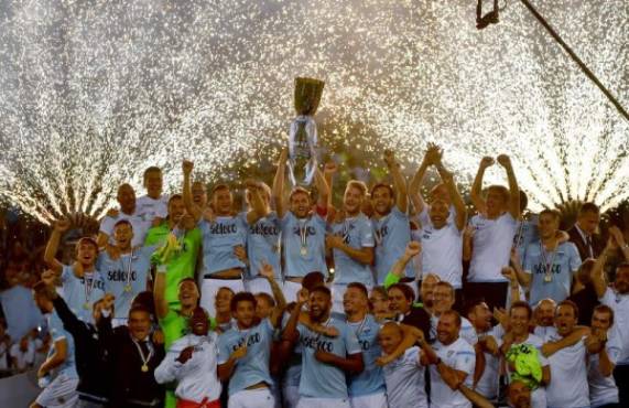 Lazio's players celebrate with the trophy after winning the Italian SuperCup TIM football match Juventus vs lazio on August 13, 2017 at the Olympic stadium in Rome. / AFP PHOTO / Alberto PIZZOLI
