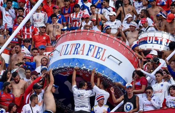 Los aficionados del Olimpia cargan el enorme bombo que llevan para alentar al club en todos los estadios.