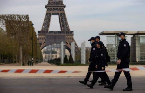 Paris (France), 07/04/2020.- Police officers patrol past the Eiffel Tower and the Champs de Mars parc in Paris, France, 07 April 2020. France is under lockdown in an attempt to stop the widespread of the SARS-CoV-2 coronavirus causing the Covid-19 disease. (Francia) EFE/EPA/IAN LANGSDON
