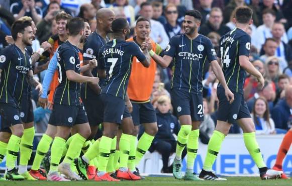 Manchester City's Algerian midfielder Riyad Mahrez (2R) celebrates scoring their third goal during the English Premier League football match between Brighton and Hove Albion and Manchester City at the American Express Community Stadium in Brighton, southern England on May 12, 2019. (Photo by Glyn KIRK / AFP) / RESTRICTED TO EDITORIAL USE. No use with unauthorized audio, video, data, fixture lists, club/league logos or 'live' services. Online in-match use limited to 120 images. An additional 40 images may be used in extra time. No video emulation. Social media in-match use limited to 120 images. An additional 40 images may be used in extra time. No use in betting publications, games or single club/league/player publications. /