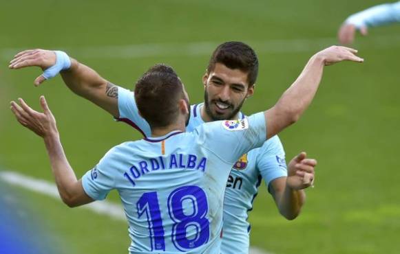 Barcelona's Spanish defender Jordi Alba (L) is congratulated by teammate Uruguayan forward Luis Suarez for scoring the team's second goal during the Spanish league football match between SD Eibar and FC Barcelona at the Ipurua stadium in Eibar on February 17, 2018. / AFP PHOTO / ANDER GILLENEA