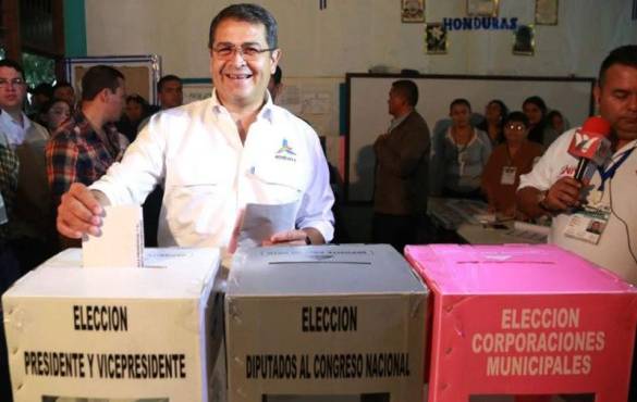 This handout picture released by Honduras' Presidency shows Honduran President Juan Orlando Hernandez, casting his ballot at a polling station in Gracias, Lempira department, 180 km from Tegucigalpa, during the general election on November 26, 2017. Honduras' six million voters are to cast ballots in a controversial election Sunday in which President Juan Orlando Hernandez is seeking a second mandate despite a constitutional one-term limit. This small country is at the heart of Central America's 'triangle of death,' an area plagued by gangs and poverty. / AFP PHOTO / Honduras' Presidency / HO / RESTRICTED TO EDITORIAL USE - MANDATORY CREDIT 'AFP PHOTO / Honduras' Presidency' - NO MARKETING NO ADVERTISING CAMPAIGNS - DISTRIBUTED AS A SERVICE TO CLIENTS / “The erroneous mention[s] appearing in the metadata of this photo by HO has been modified in AFP systems in the following manner: [in Gracias, Lempira department, 180 km from Tegucigalpa] instead of [Tegucigalpa]. Please immediately remove the erroneous mention[s] from all your online services and delete it (them) from your servers. If you have been authorized by AFP to distribute it (them) to third parties, please ensure that the same actions are carried out by them. Failure to promptly comply with these instructions will entail liability on your part for any continued or post notification usage. Therefore we thank you very much for all your attention and prompt action. We are sorry for the inconvenience this notification may cause and remain at your disposal for any further information you may require.”