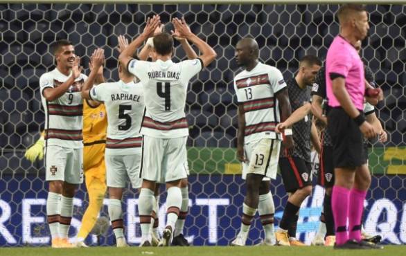 Portugal's forward Andre Silva (L) celebrates with teammates after scoring a goal during the UEFA Nations League A group 3 football match between Portugal and Croatia at the Dragao Stadium in Porto on September 5, 2020. (Photo by MIGUEL RIOPA / AFP)