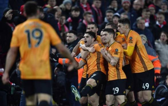 Wolverhampton Wanderers' Portuguese midfielder Pedro Neto (L) celebrates with team-mates after putting the ball in the Liverpool net, a goal that was subsequently ruled out by VAR due to an offside in the build up to it during the English Premier League football match between Liverpool and Wolverhampton Wanderers at Anfield in Liverpool, north west England, on December 29, 2019. (Photo by Paul ELLIS / AFP) / RESTRICTED TO EDITORIAL USE. No use with unauthorized audio, video, data, fixture lists, club/league logos or 'live' services. Online in-match use limited to 120 images. An additional 40 images may be used in extra time. No video emulation. Social media in-match use limited to 120 images. An additional 40 images may be used in extra time. No use in betting publications, games or single club/league/player publications. /