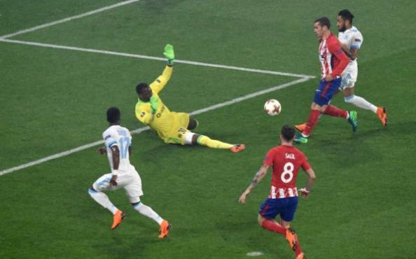 Atletico Madrid's French forward Antoine Griezmann (topL) scores his second goal past Marseille's French goalkeeper Steve Mandanda (2ndL) during the UEFA Europa League final football match between Olympique de Marseille and Club Atletico de Madrid at the Parc OL stadium in Decines-Charpieu, near Lyon on May 16, 2018. / AFP PHOTO / Jean-Philippe KSIAZEK