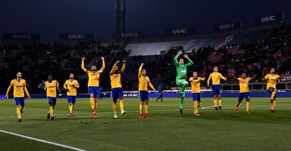 Juventus's players celebrate at the end of the Italian Serie A football match Bologna vs Juventus on December 17, 2017 at Renato Dall'Ara stadium in Bologna. / AFP PHOTO / ALBERTO PIZZOLI