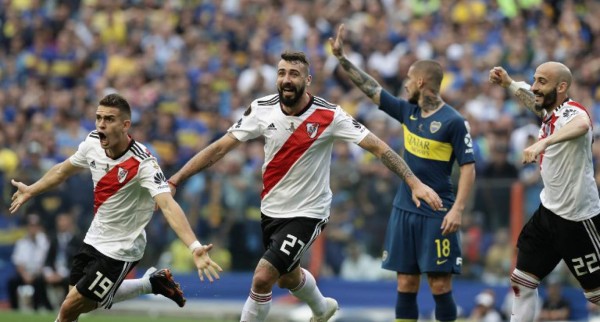 (L-R) River Plate's Rafael Santos Borre, Lucas Pratto and Javier Pinola celebrate after an own goal by Boca Juniors' Carlos Izquierdoz during their first leg match of the all-Argentine Copa Libertadores final, at La Bombonera stadium in Buenos Aires, on November 11, 2018. (Photo by Alejandro PAGNI / AFP)
